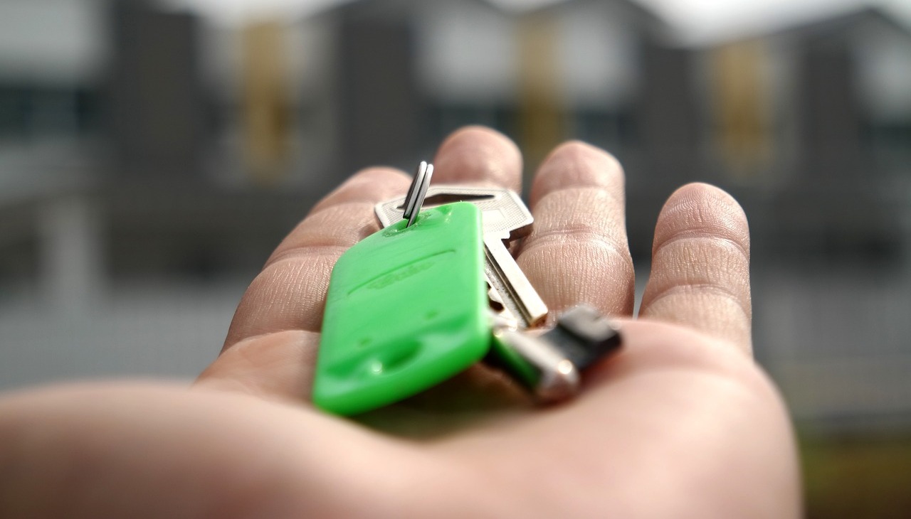 A hand holding a set of house keys.