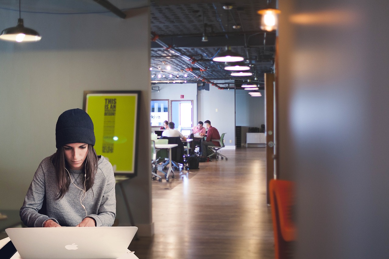 Girl working on a laptop in a co-working space.