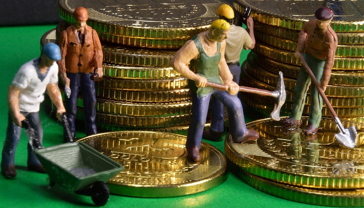 Working men action figures placed along several coins. 