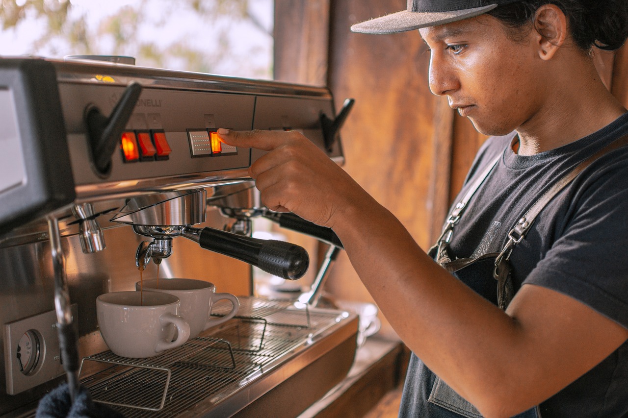 Man fixing an expresso coffee in a coffee shop. 