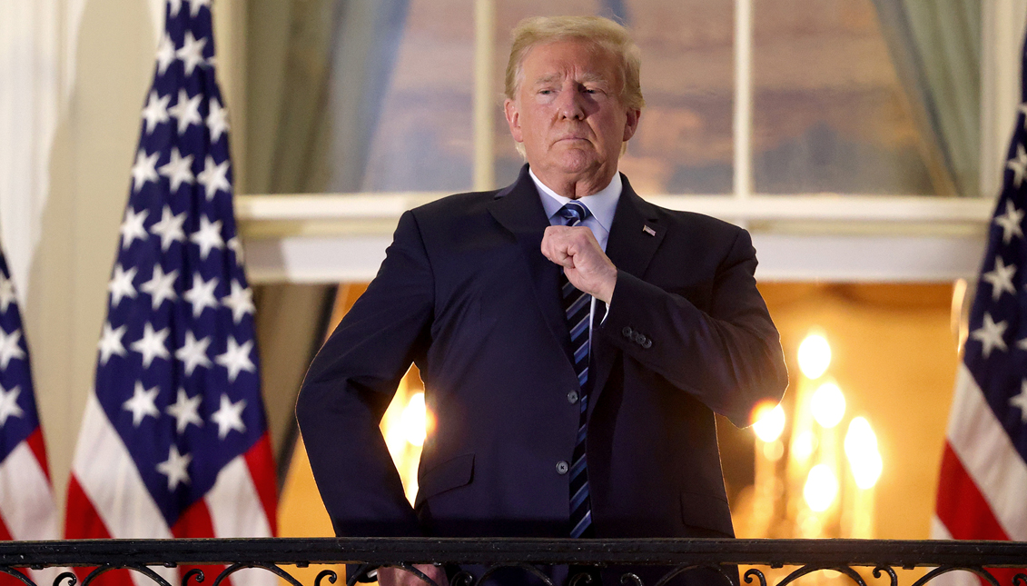 U.S. President Donald Trump gestures on the Truman Balcony after returning to the White House from Walter Reed National Military Medical Center on October 05, 2020 in Washington, DC. Trump spent three days hospitalized for coronavirus. (Photo by Win McNamee/Getty Images)