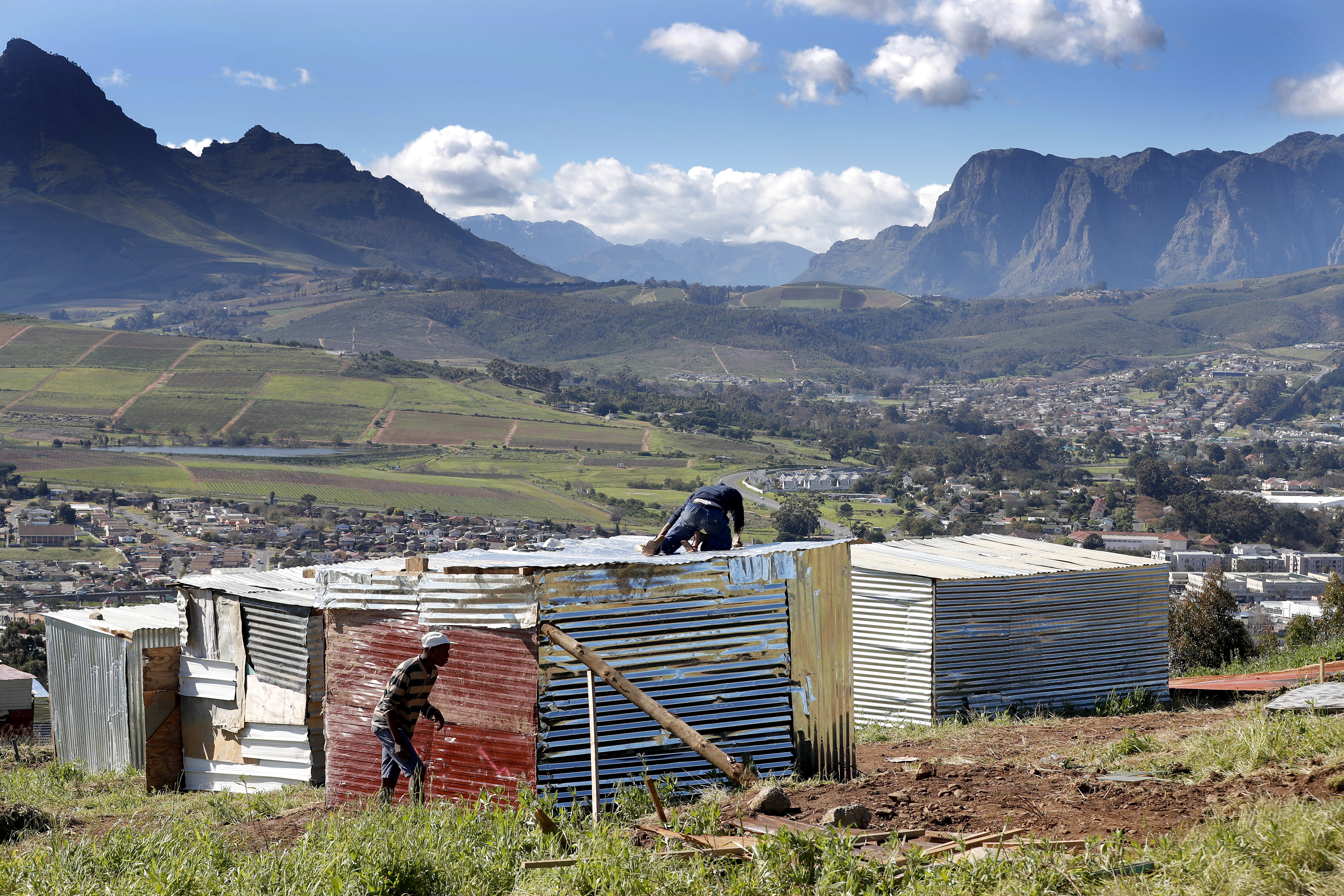 File photo showing South African men building an illegally erected shack during a land invasion on the property of Louiesenhof Wine farm in the heart of the major wine producing region of Stellenbosch, South Africa, Aug. 8, 2018. EPA-EFE/Nic Bothma
