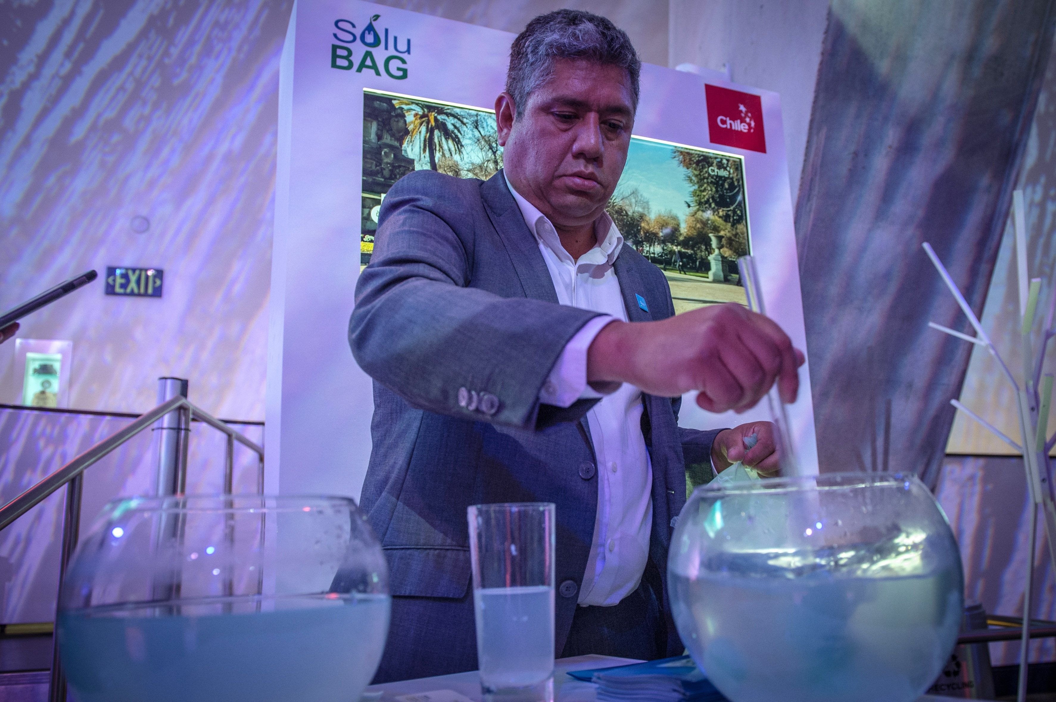 Patricio Cabezas shows how the biodegradable plastic grocery bags manufactured by his Chilean firm - Solubag - dissolves in water in just three minutes at an event in Miami on Dec. 4, 2018.  EFE-EPA/Giorgio Viera
