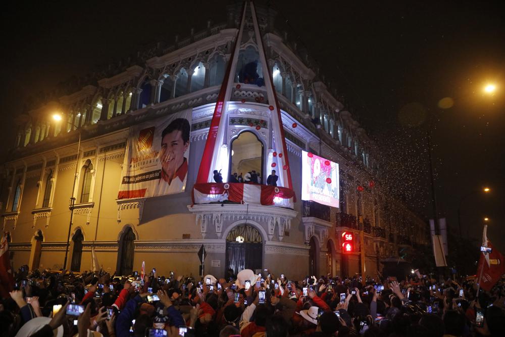 Pedro Castillo celebrates with Dina Boluarte from the balcony of his campaign headquarters in Lima, after being declared president of Peru by the electoral authorities. Monday, July 19, 2021. AP Photo by Guadalupe Prado.