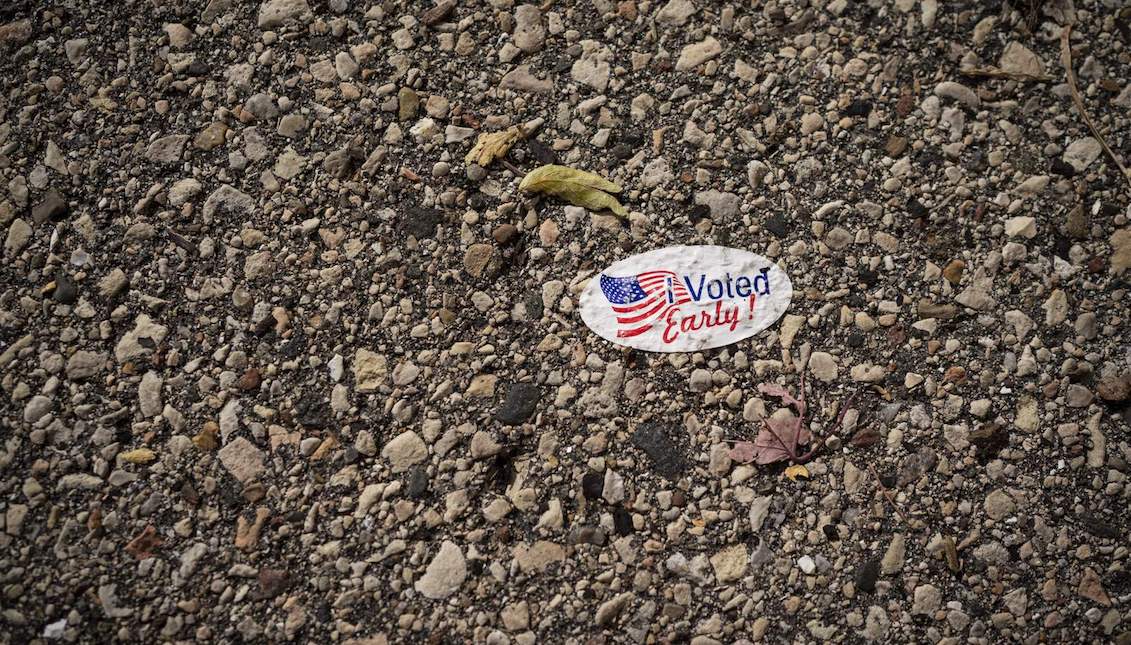An early voter sticker is posted on a sidewalk outside the Kenosha municipal offices for early voting on Friday, October 30, 2020, in Kenosha, Wisconsin. (AP Photo/Wong Maye-E)