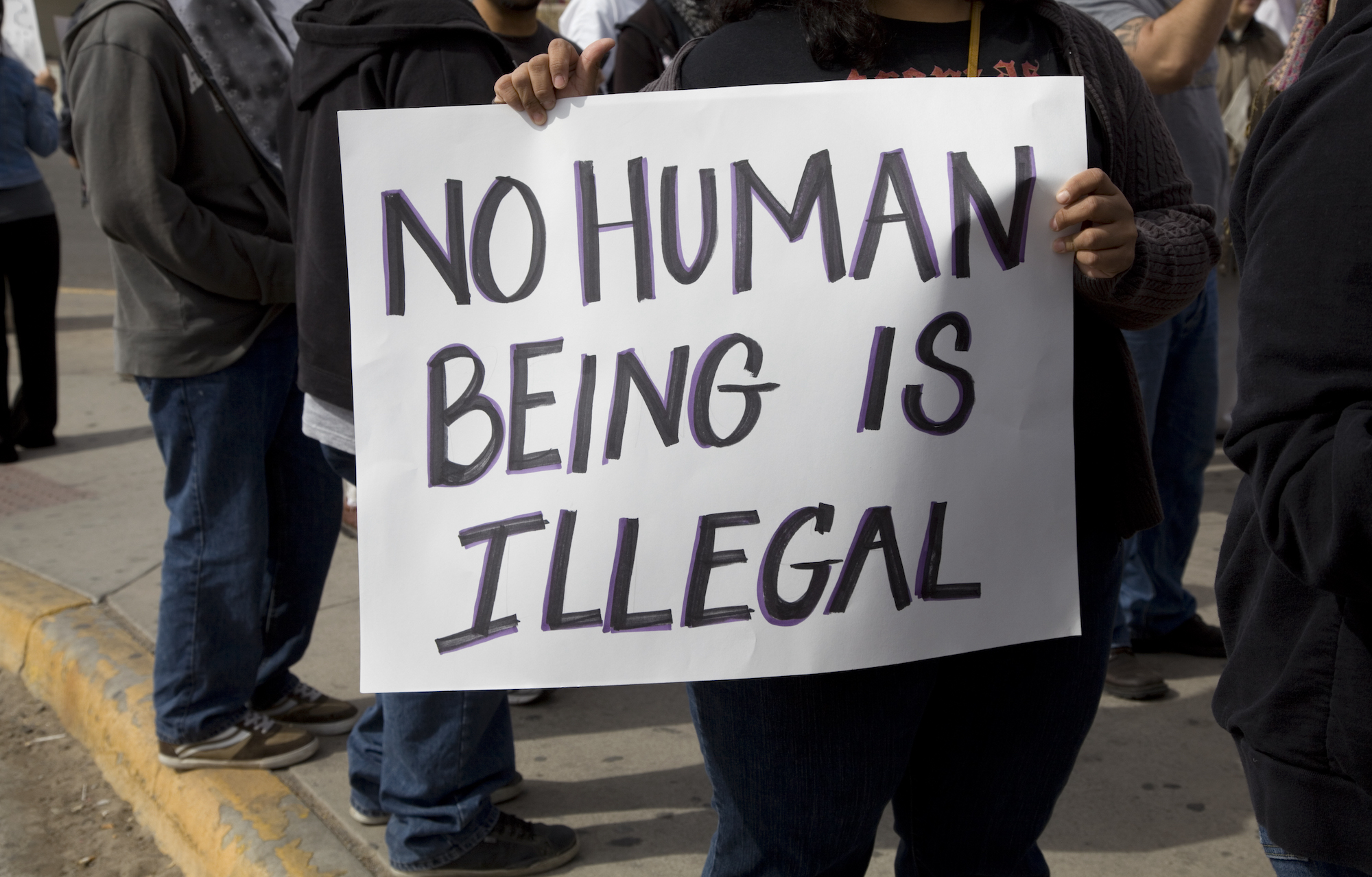 "No Human Being is Illegal" poster. Photo: Vallarie Enriquez/Getty Images
