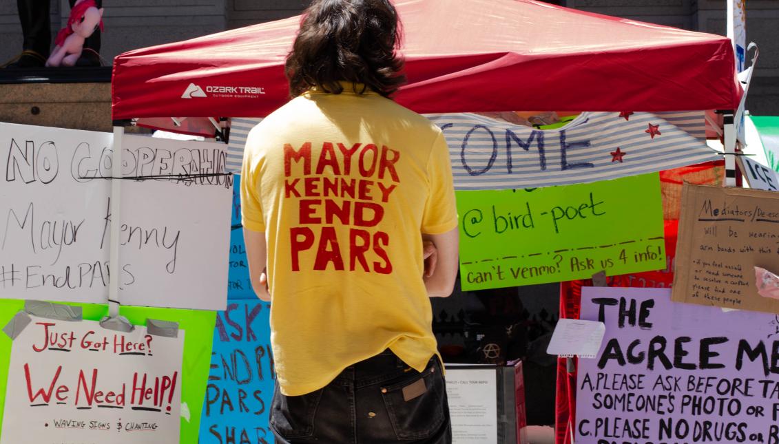 Philly Democratic Socialist Association member Jamie Rush sports an "End PARS" shirt at the Occupy ICE PHL encampment on the east side of City Hall. Greta Anderson / AL DÍA News
